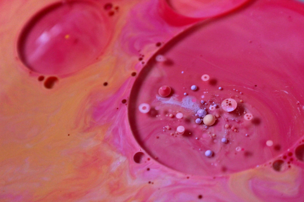 A colourful, artistic photo of what seems to be abstract bubbles. An explosion of orange and pink, saturated tones in circular shapes.